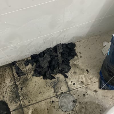 רצפה מלוכלכת עם סמרטוטים שחורים ליד שירותים