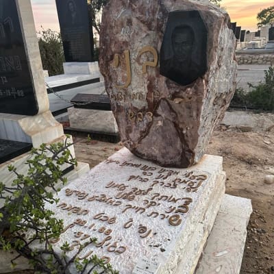 מצבה עם כיתוב בעברית ותמונה חקוקה באבן