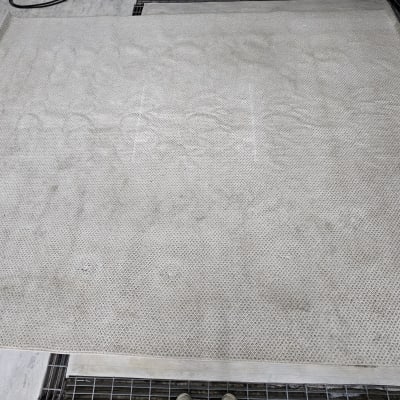 שטיח בהיר עם כתמים קלים על רצפה אפורה