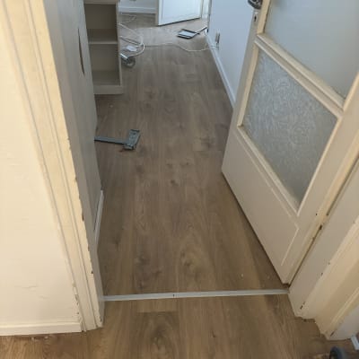 רצפת עץ עם כלי עבודה ודלת פתוחה