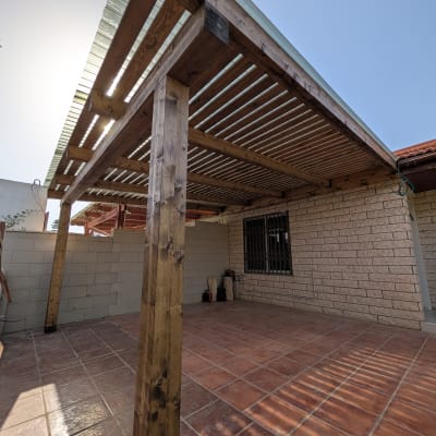 פרגולה מעץ בחצר עם רצפת אריחים