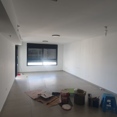 חדר עם ציוד לצביעה, כולל דלי צבע ומברשת.