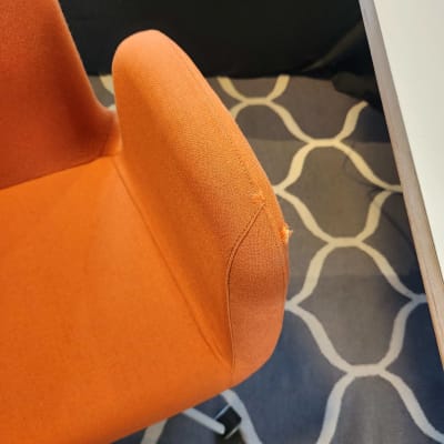 כיסא כתום על שטיח עם דוגמה גיאומטרית