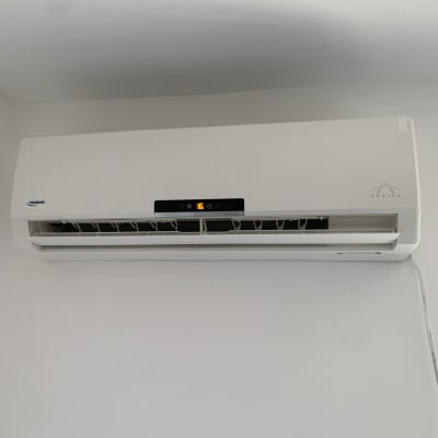 מזגן קיר לבן עם תצוגה דיגיטלית ופאנל פתוח