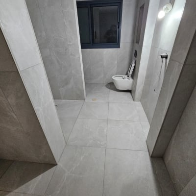 חדר אמבטיה עם שירותים וקירות מרוצפים