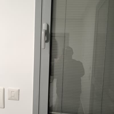 חלון עם תריסים פנימיים ומתג על הקיר