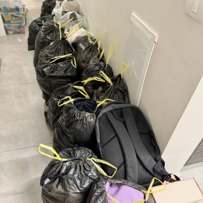 שקיות זבל שחורות עם ידיות צהובות מסודרות במסדרון