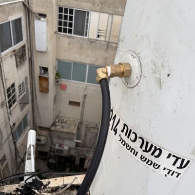 דוד שמש עם חיבורי צנרת על גג בניין