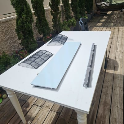 חלקי מזגן על שולחן לבן בחוץ