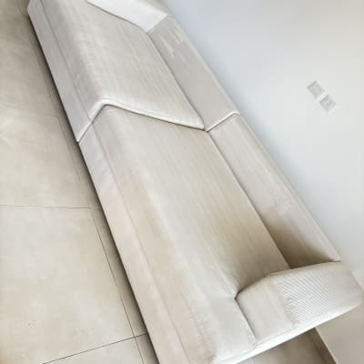 ספה בהירה על רצפת אריחים, ללא אנשים או טקסט.