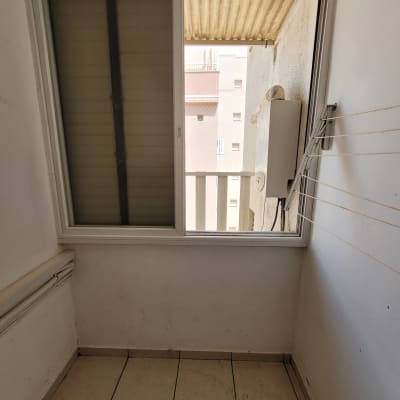 מרפסת עם חלון פתוח ורצפה מלוכלכת