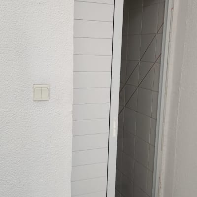 דלת הזזה לבנה עם ידית, פתוחה למחצה