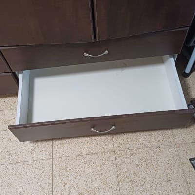 מגירה פתוחה בארון עץ על רצפת קרמיקה