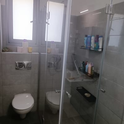 מקלחת עם מדף בקבוקים ודלת זכוכית