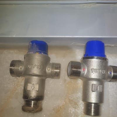 שני שסתומים עם מכסים כחולים על משטח לבן