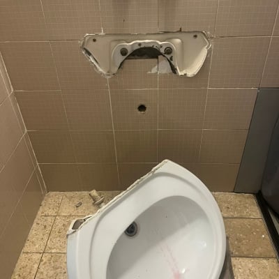 כיור שבור על הרצפה, צינור מים חשוף