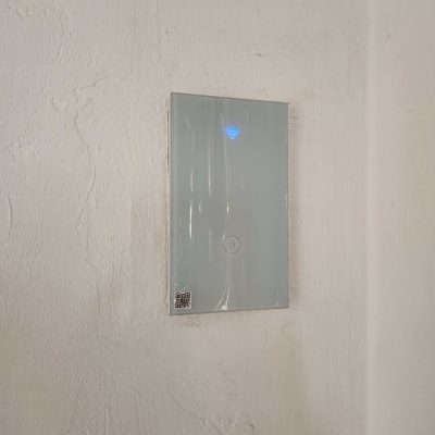 מתג חשמלי עם תאורה כחולה על קיר לבן