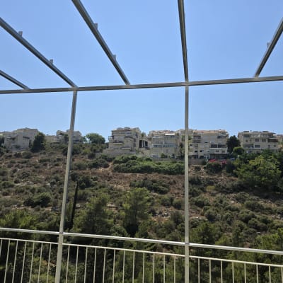 מסגרת מתכת מול נוף של בניינים וגבעות