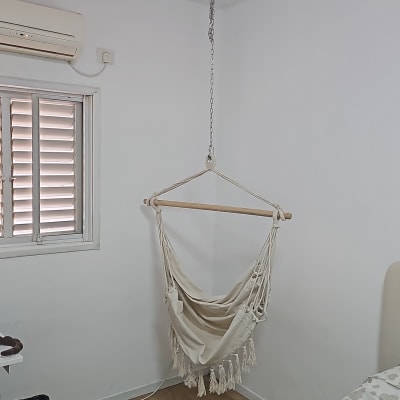 כיסא תלוי מחובר לתקרה בחדר עם מזגן