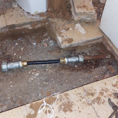 צינור מים עם מחברים על רצפה חשופה