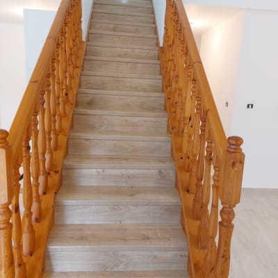 מדרגות עץ נקיות ומבריקות עם מעקה מעוצב
