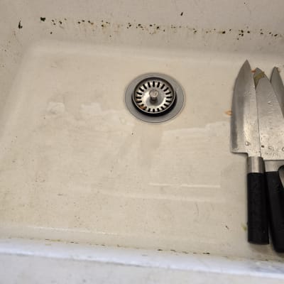 כיור עם ניקוז וסכינים מונחים בצד