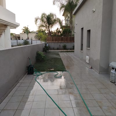 צינור מים ירוק על רצפת מרפסת רטובה