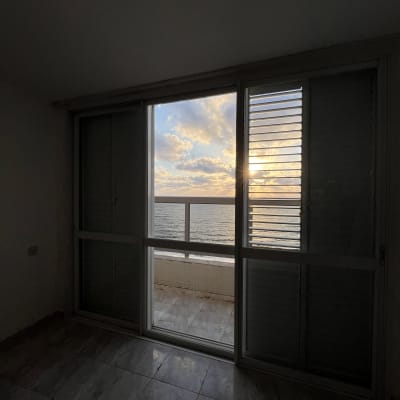 נוף ים מבעד לחלון זכוכית בשקיעה