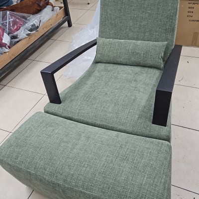 כיסא מרופד ירוק עם משענות שחורות בחדר עבודה