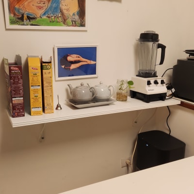 מדף עם קופסאות דגנים, קומקום, בלנדר ותמונה על הקיר