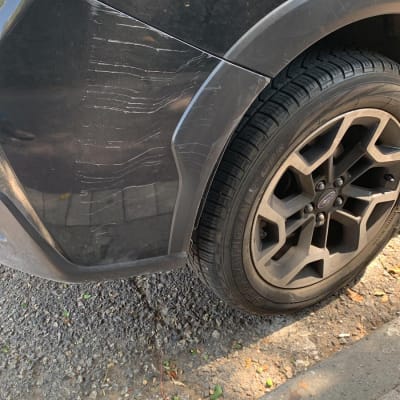 שריטות על דלת רכב שחורה ליד גלגל אחורי