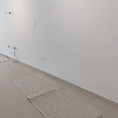 קיר צבוע עם מזגן ומחצלות על הרצפה