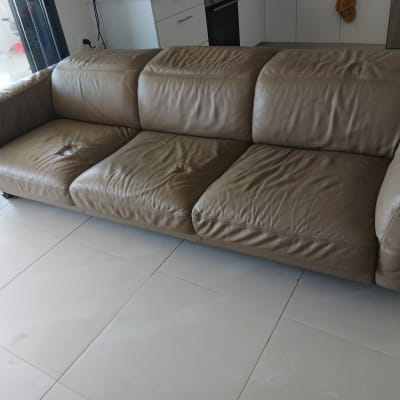 ספה חומה על רצפת אריחים לבנה