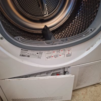 תוף מכונת כביסה פתוח עם דלת תחתונה פתוחה