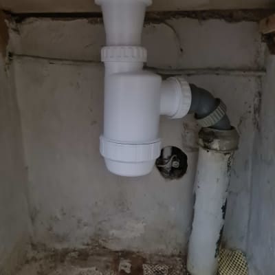 צינור ניקוז לבן מתחת לכיור במטבח