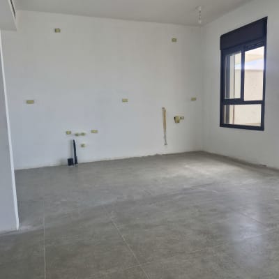 חדר ריק עם קירות לבנים ורצפת אריחים