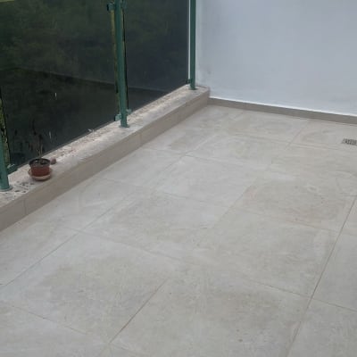 מרפסת עם ריצוף חדש ומעקה זכוכית