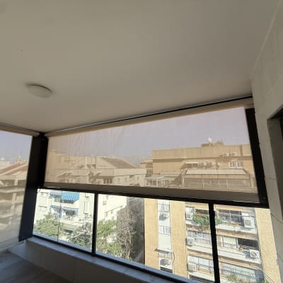 מרפסת עם סוככים שקופים לנוף עירוני
