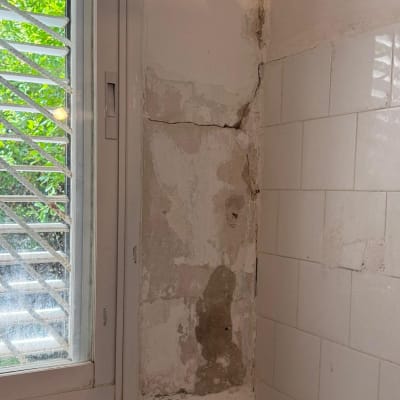 קיר עם סדקים ליד חלון, מתאים לתיקון הנדימן