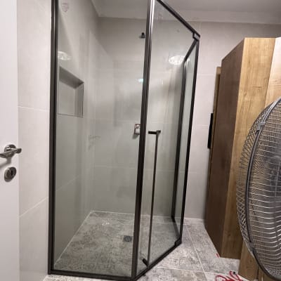 מקלחון זכוכית עם מסגרת מתכת בחדר אמבטיה