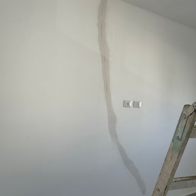 קיר עם תיקון סדק וסולם עץ בצד