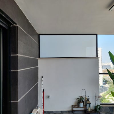 חלון אלומיניום עם מסגרת שחורה על קיר לבן