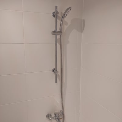 ברז מקלחת עם ראש טוש מתכוונן על קיר אריחים