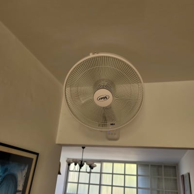 מאוורר קיר לבן מותקן על קיר פנימי