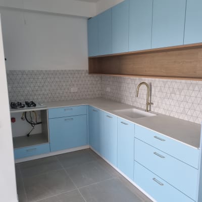 מטבח עם ארונות כחולים, כיור וברז זהב