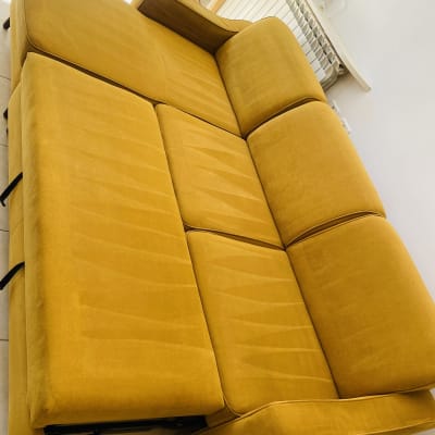 ספה צהובה נקייה ומסודרת בחדר מואר