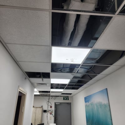 תקרת גבס עם לוחות חסרים וצינורות חשופים