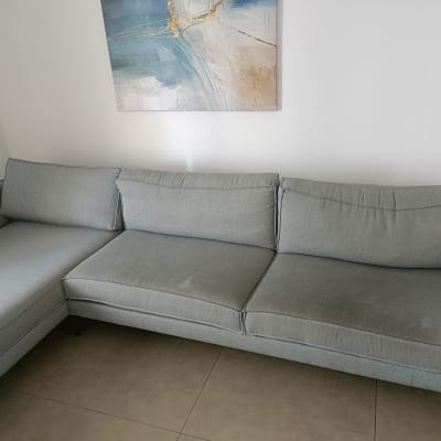 ספה אפורה בחדר עם תמונה על הקיר