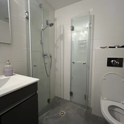 מקלחת עם דלתות זכוכית ושירותים