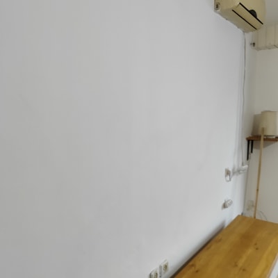 קיר לבן עם שקעי חשמל ומזגן עליון